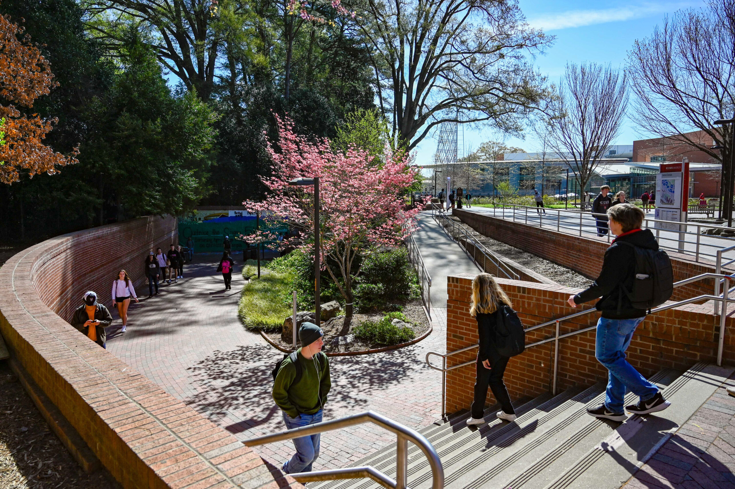 Students walk down stairs and a sidewalk near the Free Expression Tunnel