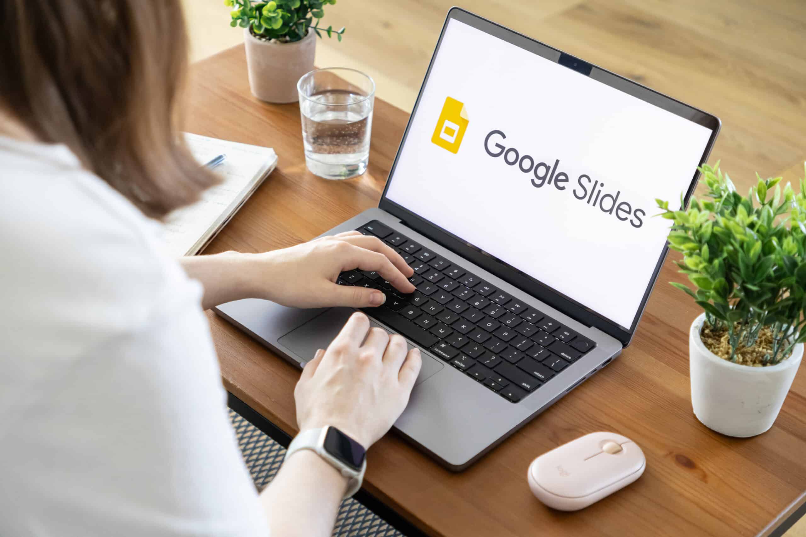 Person works on computer showing Google Slides logo